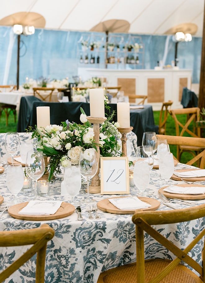 Candles, white flowers and blue linens decorate the outdoor tented wedding in Houston. 