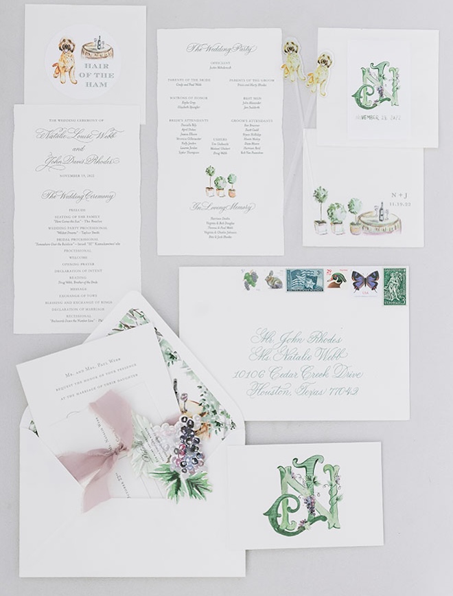 A flat lay of the bride and groom's green and blue wedding invitation and stationery. 