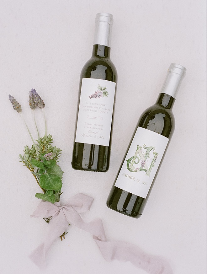 Red wine bottles have custom labels featuring the bride and grooms initials and wedding date. 