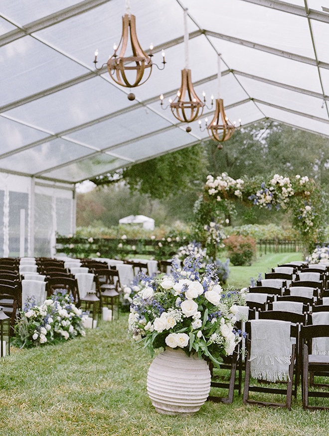 The bride and groom wed with an outdoor tented wedding in Houston with blue and white florals. 