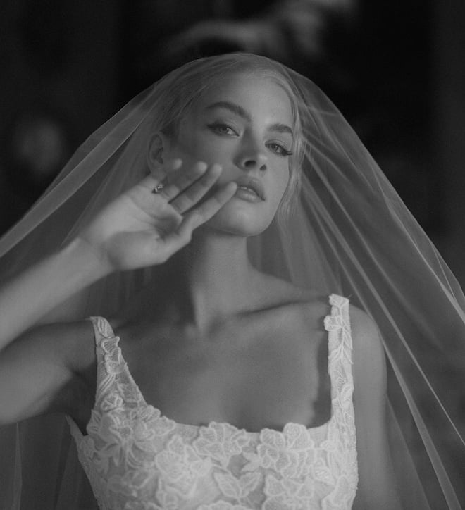 Black and white photo of a bride wearing a puffer and scoop neck embroidered gown. 