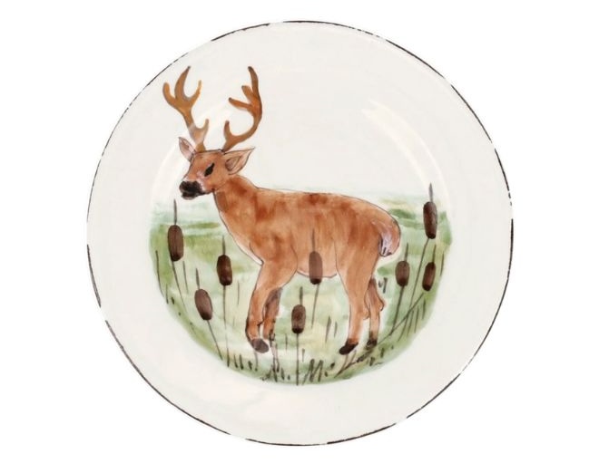 A salad plate with a deer standing in grass. 