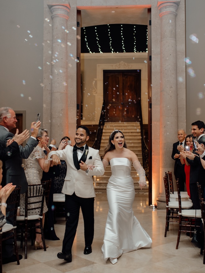 The bride and groom walk into their wedding reception with a bubble enterance.