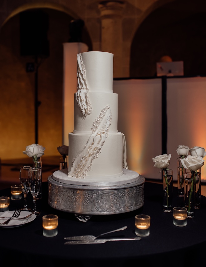 Cakes by Gina designs a three-tier white wedding cakes embellished with pearls for the black and white wedding reception.