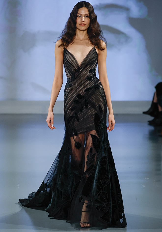 The model walks down the runway wearing a dark-colored wedding dress by Ines Di Santo. 