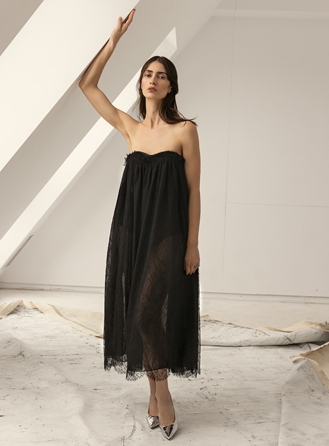 The model wears a black dress with lace trim by Soucy. 