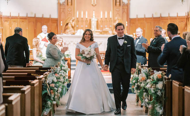 The bride and groom smile happily after saying their I do's down the aisle. 