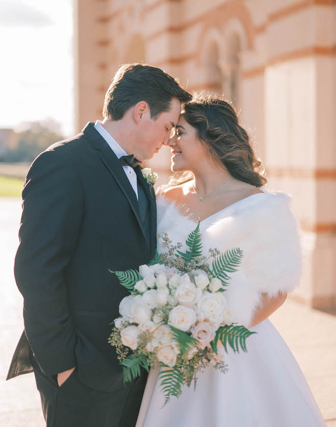 The newlyweds pose closely in front of their church ceremony. 