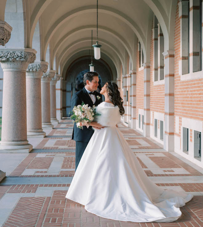 The bride and groom pose happily while looking into each-others eyes after their church ceremony. 