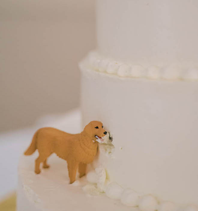 A small feature into the couple's wedding cake is their gold retriever dog on the side of the cake as a figurine. 