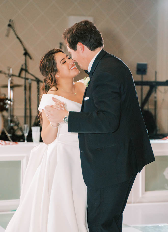 The bride and groom smile as they dance their first dance for guests to enjoy. 