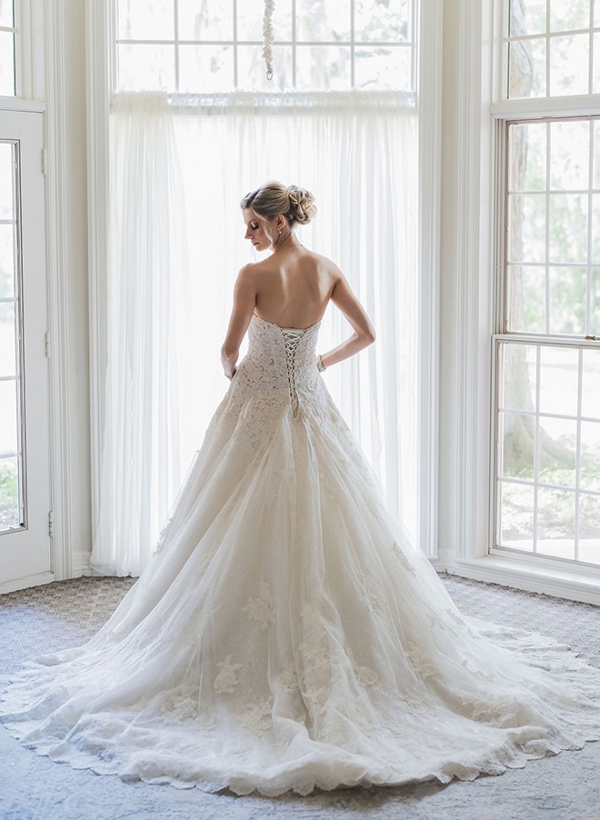 The bride looks over her shoulder wearing her wedding dress for her ceremony at The Mansion at ColoVista.