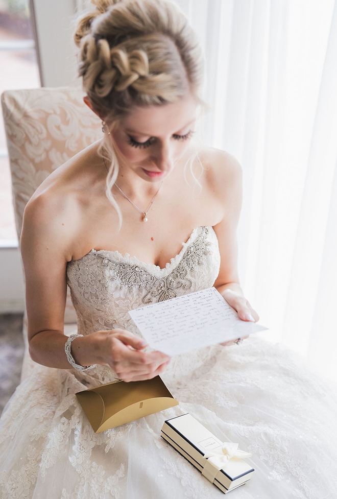 The groom gifts the bride a bottle of perfume and a handwritten note before their wedding ceremony.