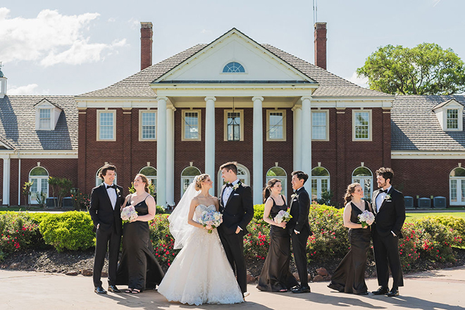 The couple and their wedding party stand outside their wedding venue The Mansion at ColoVista.