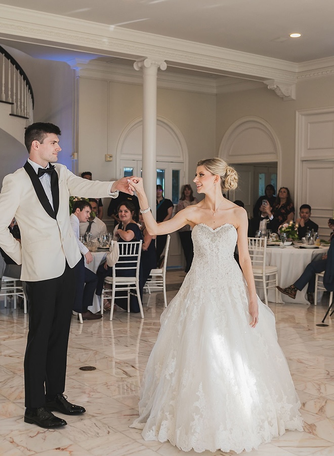 The groom dances with his bride to their first dance at the reception.