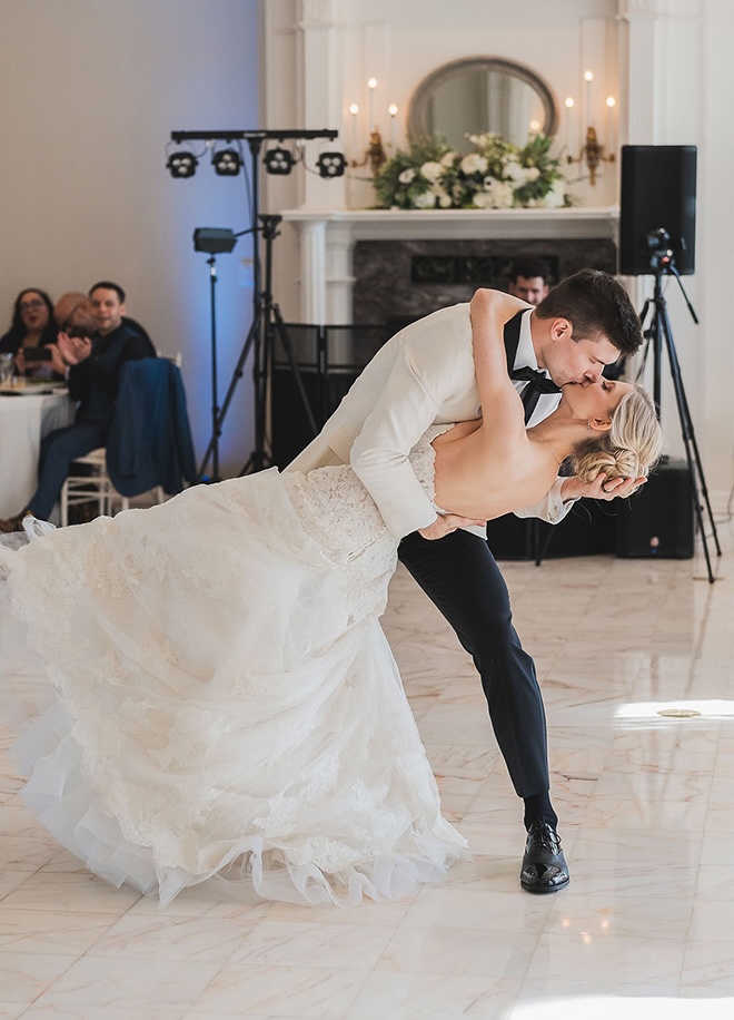 The groom dips the bride during their first dance. 