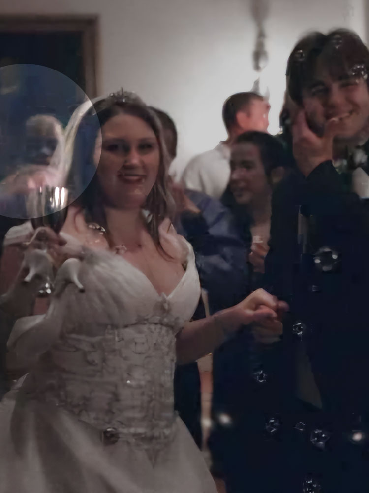 A bride and groom celebrating with a ghost highlighted behind them. 