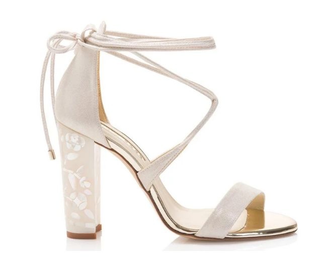 Strappy high heels in an ivory color with a pearl embellished heel detail. 