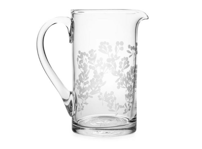 A glass pitcher with a floral print. 