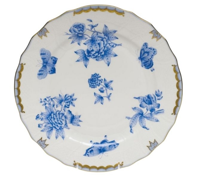 A white Herend plate with a blue floral print and gold detailing. 