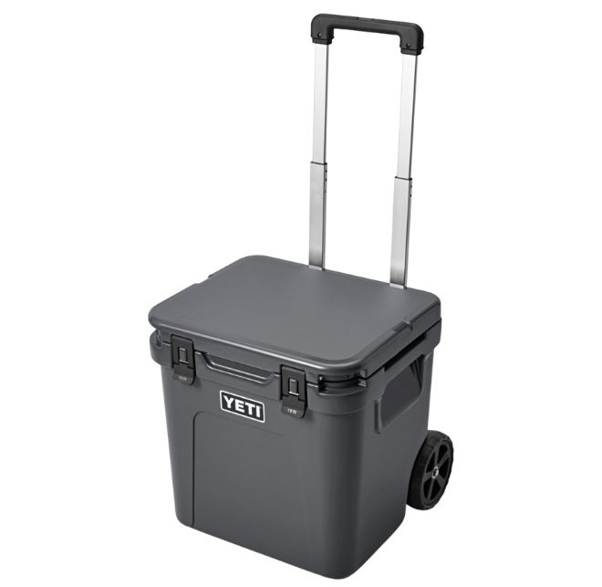 A black Yeti cooler with a handle and wheels. 