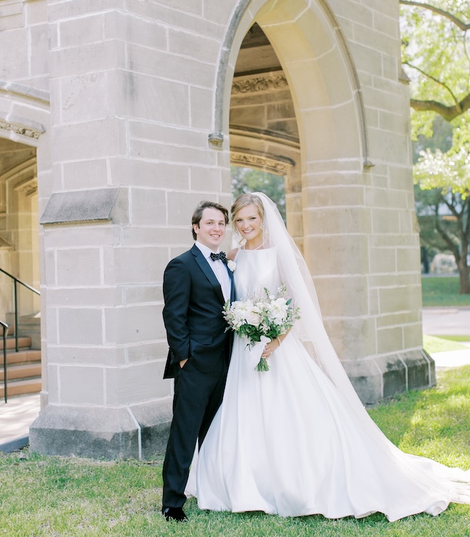 The bride and groom smiling outside of the church. 