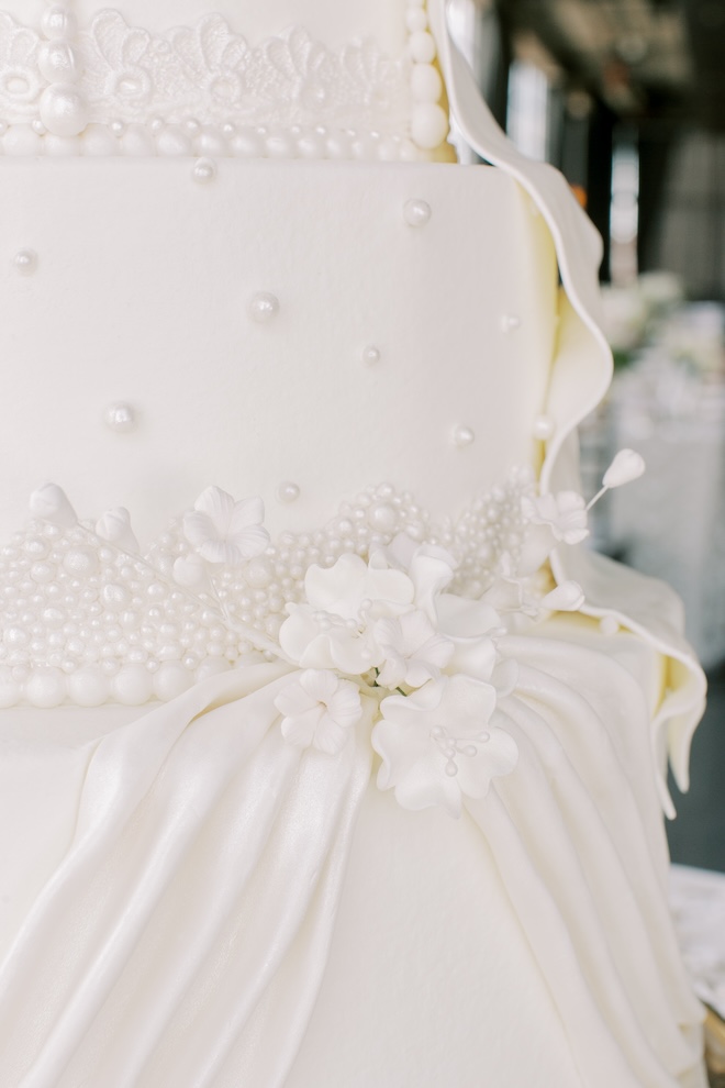 Pearl and floral detailing on the white wedding cake. 