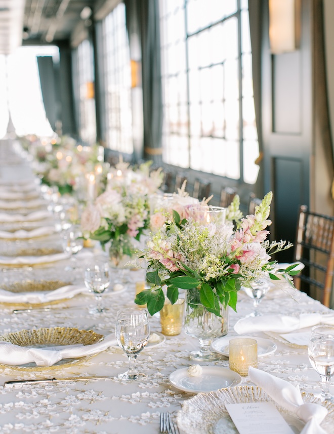 Floral arrangements with greenery and pink flowers with gold accented tablescape. 