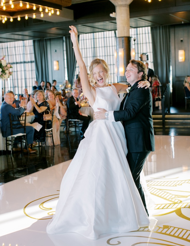 The bride and groom cheering on the dance floor. 