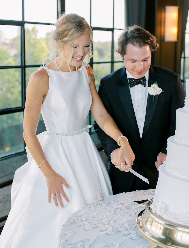 The bride and groom cutting into their wedding cake. 