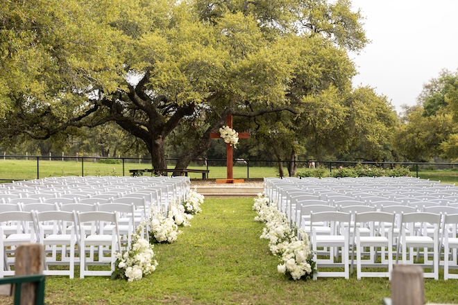 The ceremony space with a cross at the end of the aisle on a private family ranch. 