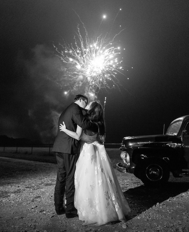 The bride and groom kissing underneath the fireworks at their ranch wedding.