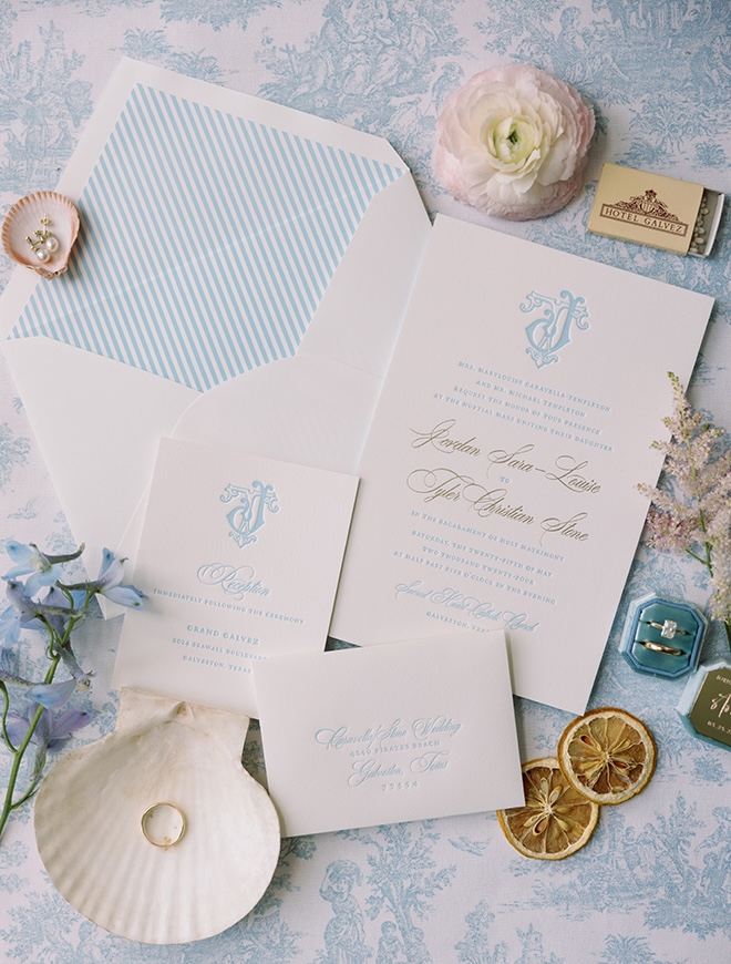 Blue and white wedding stationery from Bering's is surrounded by sea shells.