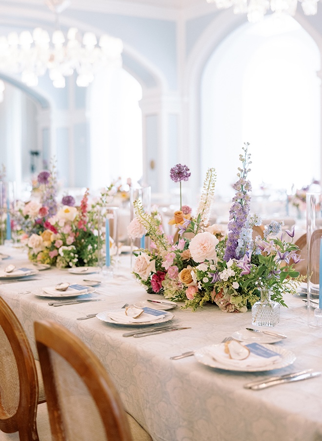 Blue taper candles and pastel florals decorate the Galveston Island wedding reception. 