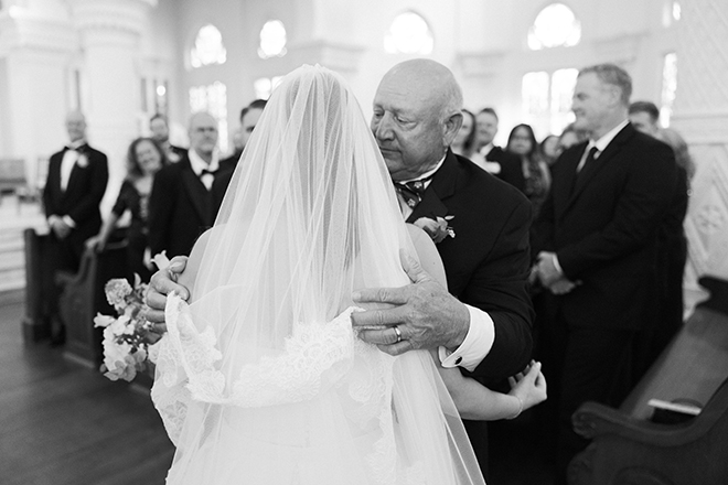 The father of the bride hugs his daughter at their wedding ceremony in Galveston Island. 