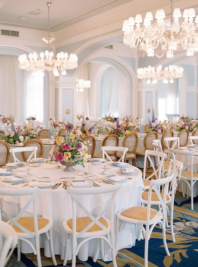 Pastel florals decorate the reception tables in the ballroom of the couple's Galveston Island wedding. 