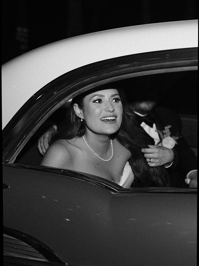 The bride and groom leave their Galveston Island wedding in a getaway car. 