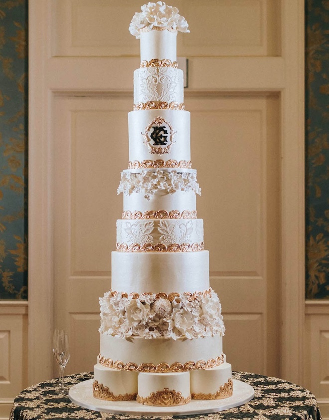 A white and gold eight-tier custom wedding cake from Cakes by Gina.