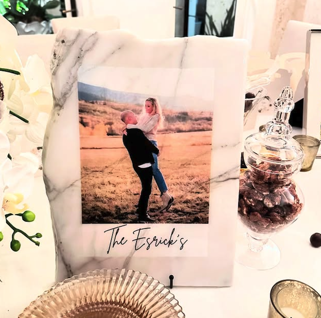 A marble plaque with a photo of a couple with "The Esrick's" written underneath the photo.