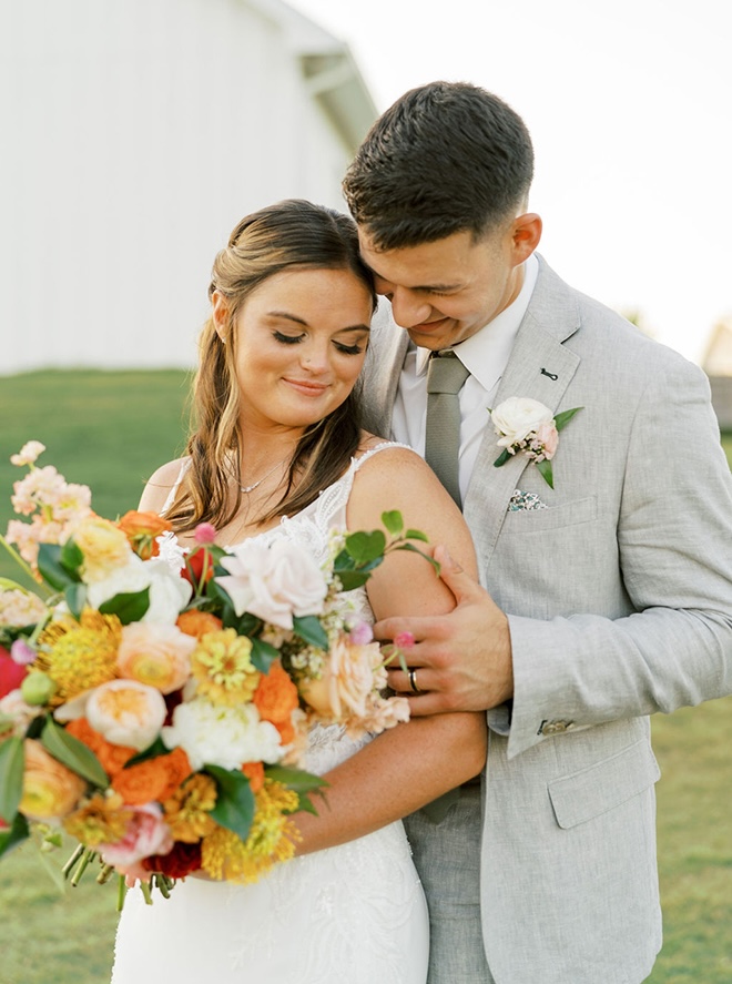 The bride and groom wed with a colorful farmhouse wedding with pink, peach and orange colors. 