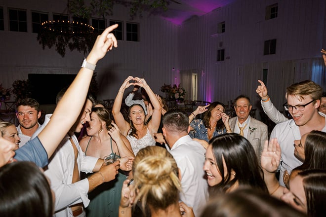 The bride and groom dance with their wedding guests. 