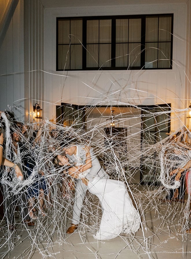 The groom dips the bride during the streamer send-off.