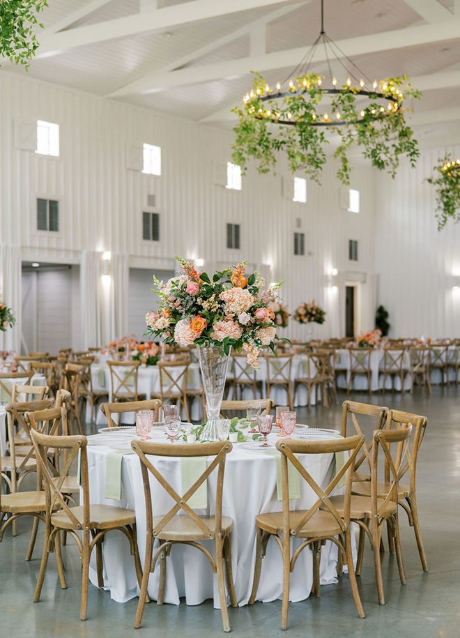 Pink, peach and orange flowers decorate the reception tables in the venue. 