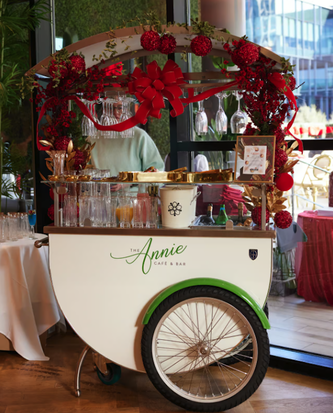 A bar cart decorated with red holiday decor at The Annie Café & Bar. 