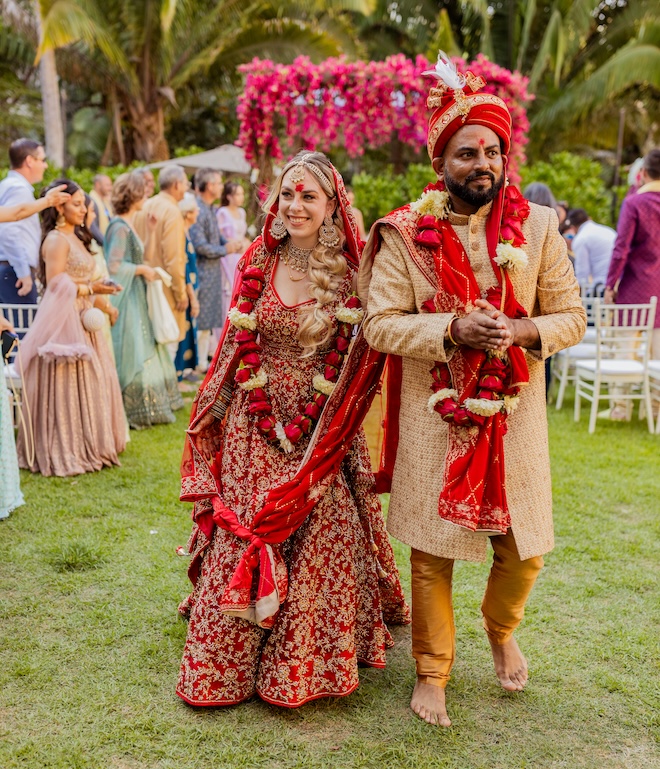 The bride and groom walking back down the aisle after their traditional Indian wedding. 