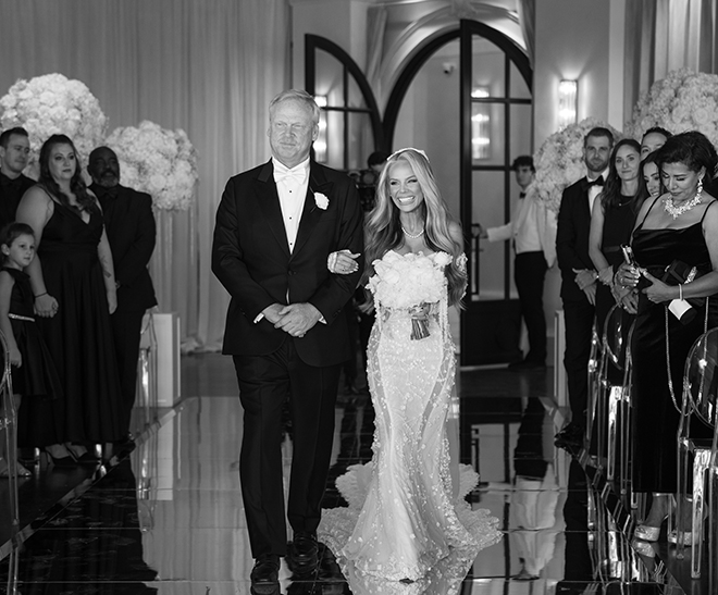 The father of the bride walks the bride down the aisle at her ceremony at the Houston wedding venue, Le Tesserae. 