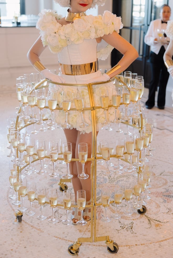 Champagne ladies in strolling Champagne skirts serve drinks during cocktail hour.