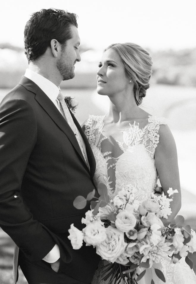 A black and white photo of a couple looking at each other romantically. 