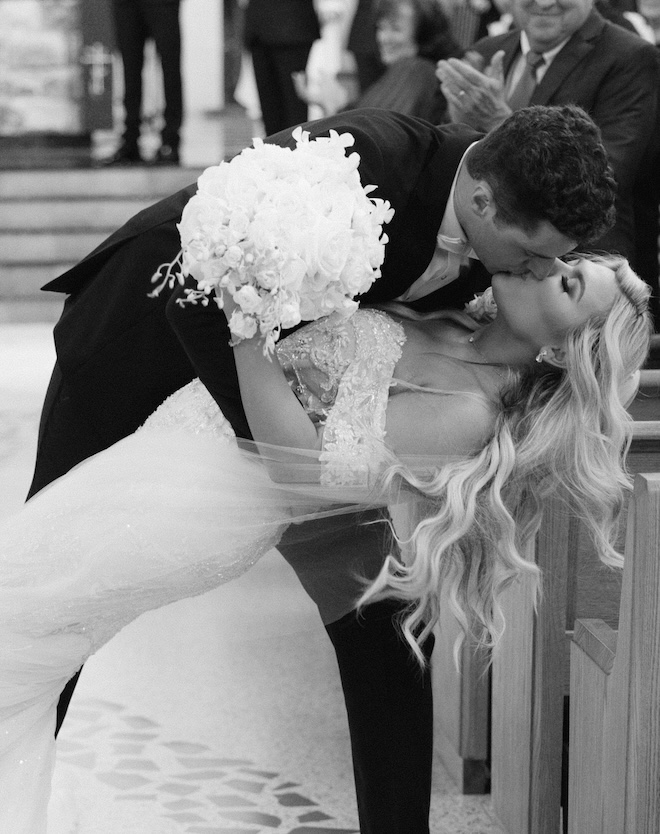 The bride and groom kissing while walking back down the aisle. 