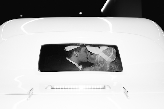 The bride and groom kissing in the getaway car. 